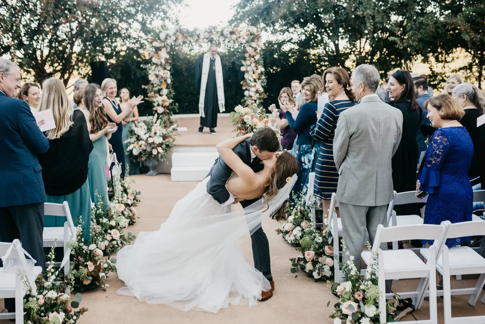 Couple kissing at the end of the aisle on the terrace